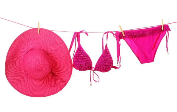 Women's swimsuit and hat hanging on a rope on white background — Stock Photo, Image