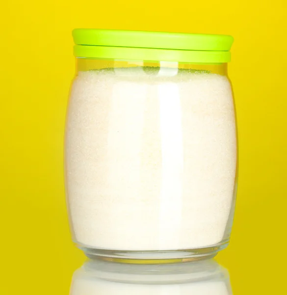 Frasco com açúcar de cristal branco sobre fundo colorido — Fotografia de Stock