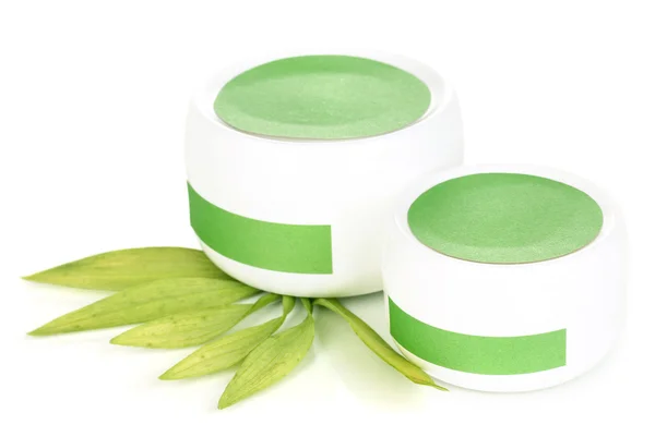 Frascos de crema con hojas verdes aisladas sobre blanco —  Fotos de Stock