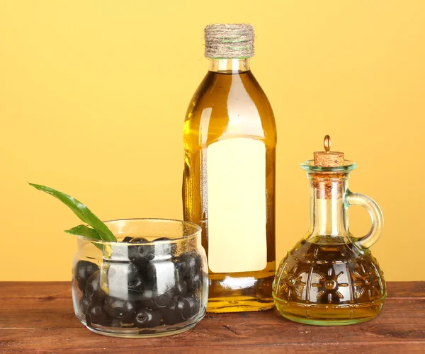 Olivolja flaska och liten karaff på gul bakgrund — Stockfoto