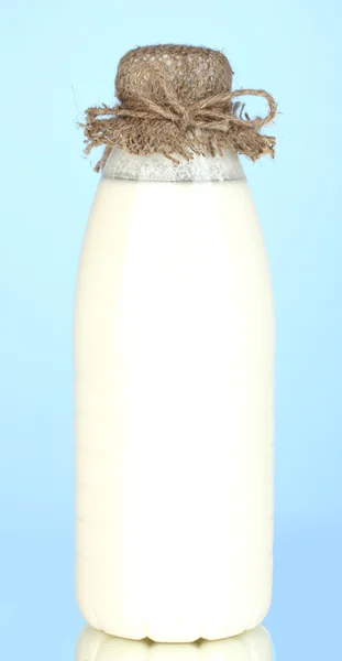 Μπουκάλι γάλα σε κοντινό πλάνο μπλε φόντο — Φωτογραφία Αρχείου