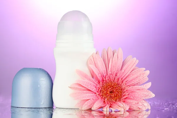 Desodorante con flor sobre fondo púrpura —  Fotos de Stock
