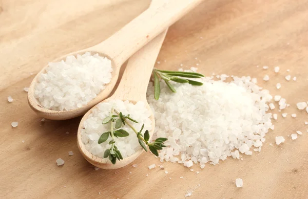 Salz in Löffeln mit frischem Rosmarin und Thymian auf Holzgrund — Stockfoto