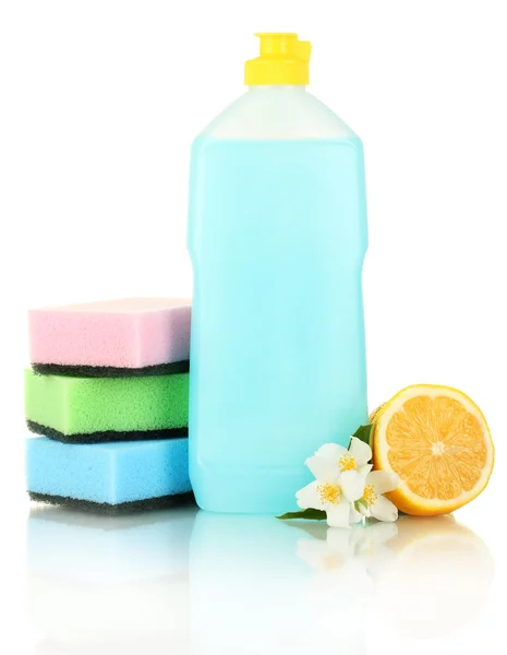 Líquido lavavajillas con esponjas y limón con flores sobre fondo azul — Foto de Stock