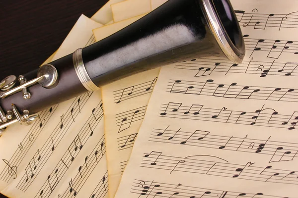 Notas musicales y clarinete sobre mesa de madera —  Fotos de Stock