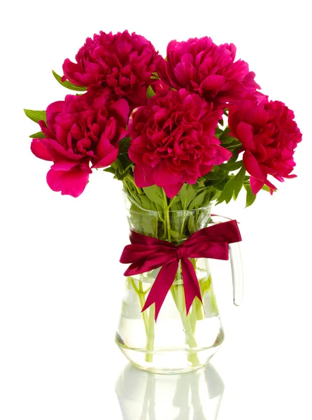 Красивые розовые пионы в стеклянной вазе с луком изолированы на белом — стоковое фото