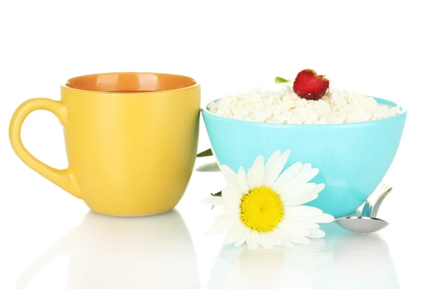 Hüttenkäse mit Erdbeere in blauer Schüssel und orangefarbener Tasse mit Kaffee, Löffel und Blume isoliert auf weiß — Stockfoto