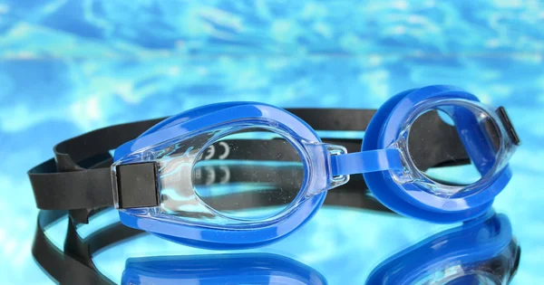 青い海の背景に滴青い水泳ゴーグル — ストック写真