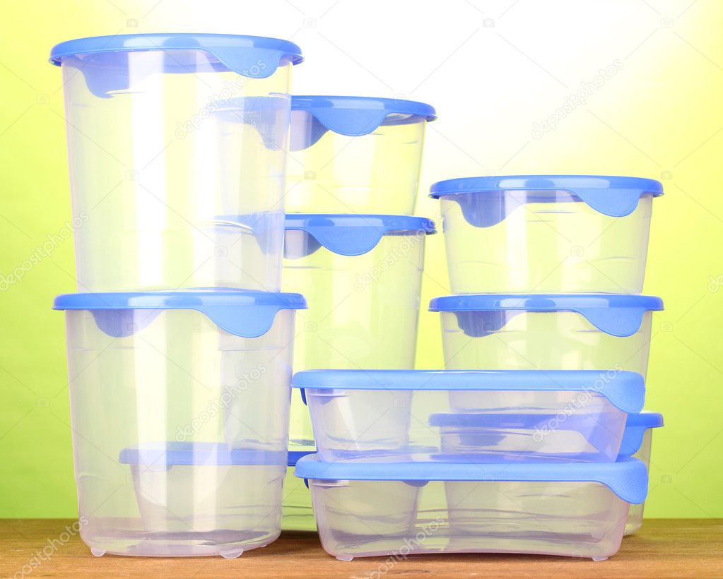 Kunststoffbehälter für Lebensmittel auf Holztisch auf grünem