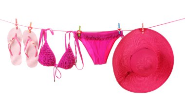 Women's swimsuit, hat and flip-flops hanging on a rope on white background clipart