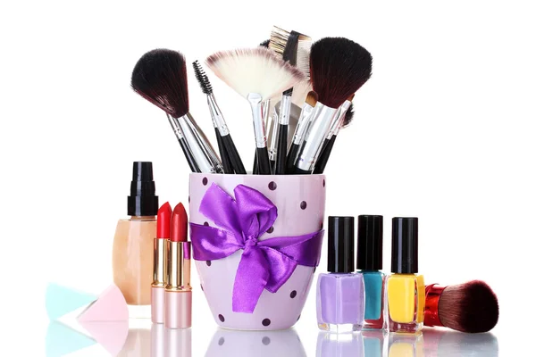 Make-up brushes in cup and cosmetics isolated on white — Stock Photo, Image