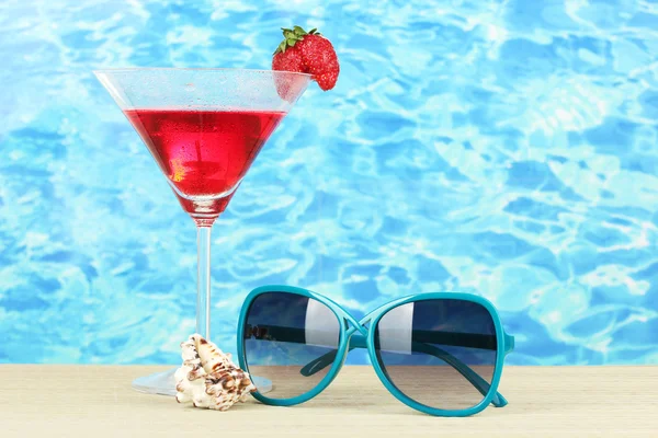 Strandkomposition aus modischen Sonnenbrillen für Frauen und einem erfrischenden Getränk — Stockfoto