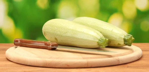 Squash on a cutting board on wooden table on green background close-up — Stock Photo, Image