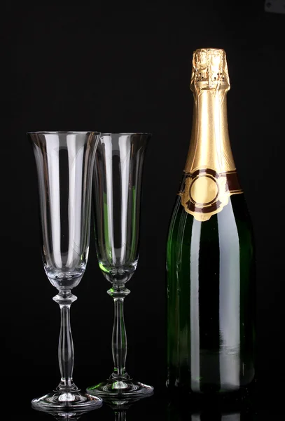 Butelka szampana i puchary na czarnym tle — Zdjęcie stockowe