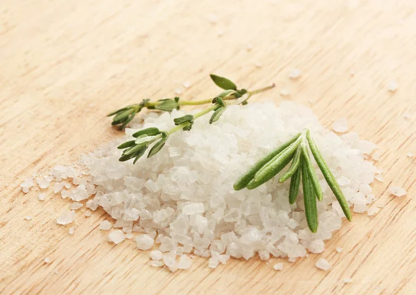 Salt with fresh rosemary and and thyme on wooden background — Stock Photo, Image