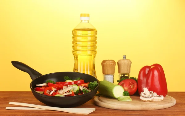 Koekenpan met groenten op gele achtergrond — Stockfoto