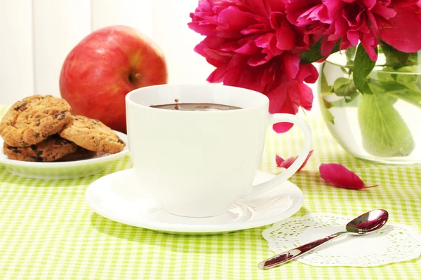 Kopp varm choklad, äpple, cookies och blommor på bord i café — Stockfoto