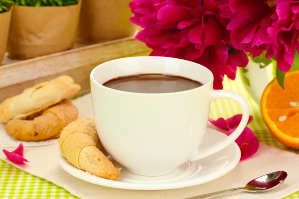 Cup hot chocolate, cookies and flowers on table in cafe — Stock Photo, Image