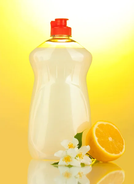 Lavavajillas líquido, limón y flores sobre fondo amarillo —  Fotos de Stock