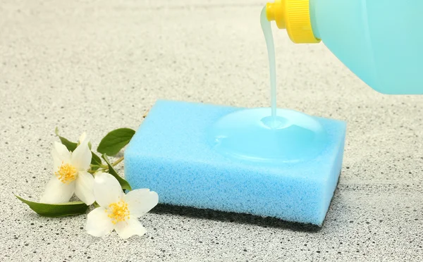 Bright sponge and flower with dish washing liquid on marble background — Stock Photo, Image