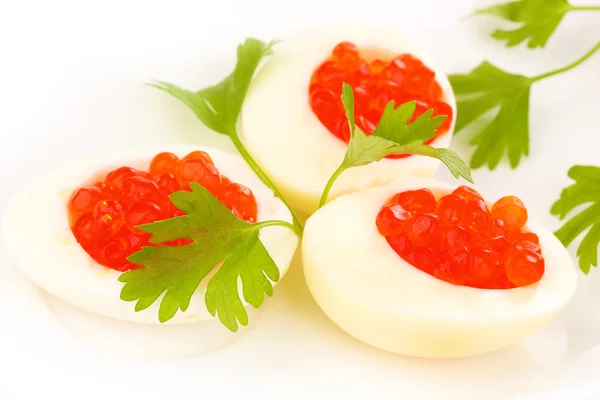 Red caviar in eggs on white plate close-up — Stock Photo, Image
