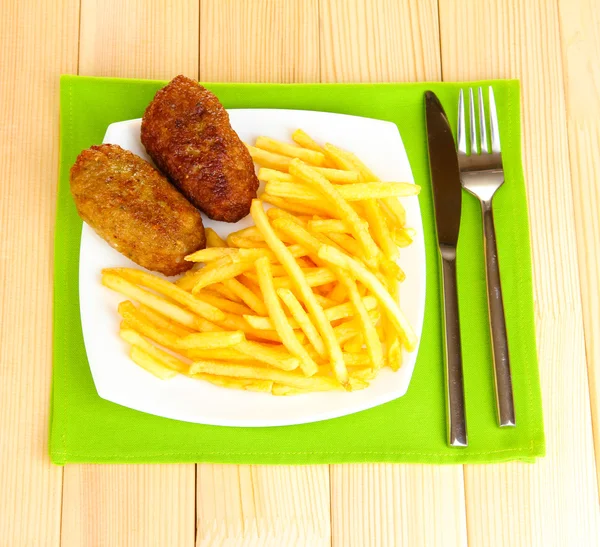 Aardappelen friet met hamburgers op de plaat op houten achtergrond close-up — Stockfoto