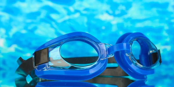 Gafas de baño azul con gotas sobre fondo marino azul — Foto de Stock