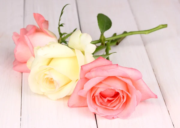 Three roses on wooden background — Stock Photo, Image