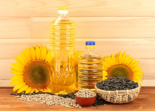 Olej słonecznikowy i słonecznik na tle drewna — Zdjęcie stockowe