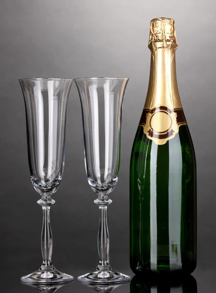 Bottiglia di champagne e calici su sfondo grigio — Foto Stock