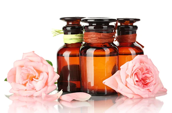 Bottiglie di olio e rose isolate su bianco — Foto Stock