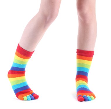 Female legs in colorful striped socks isolated on white clipart