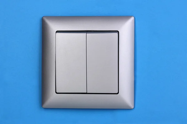 Современный выключатель света на синем фоне — стоковое фото