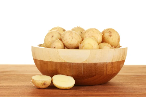 Beyaz zemin üzerinde bir tablo üzerinde bir ahşap kase genç patates — Stok fotoğraf