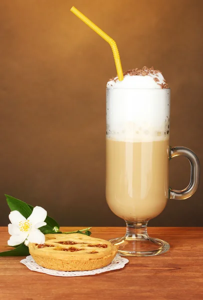 杯咖啡鸡尾酒与挞的花边和棕色背景上的花 — 图库照片