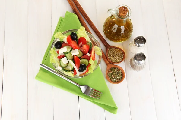 Ízletes görög saláta, fűszerek, fehér fa háttér — Stock Fotó