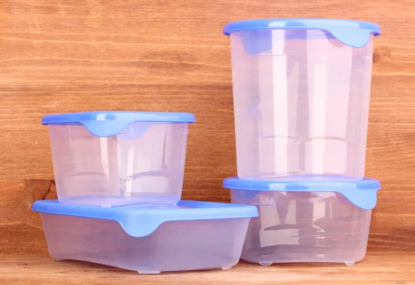 Пластиковые контейнеры для еды на деревянном фоне — стоковое фото