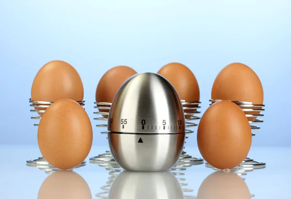Mavi zemin üzerine yumurta ve yumurta zamanlayıcı — Stok fotoğraf