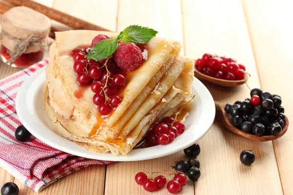 Delicious pancakes with berries, jam and honey on wooden table — Stock Photo, Image
