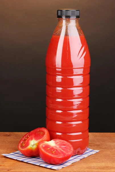 Jugo de tomate en botella sobre mesa de madera sobre fondo marrón —  Fotos de Stock