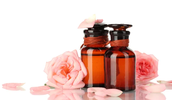 Botellas de aceite y rosas aisladas en blanco —  Fotos de Stock