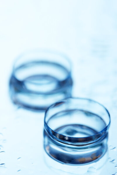 Contact lens with drops on blue background