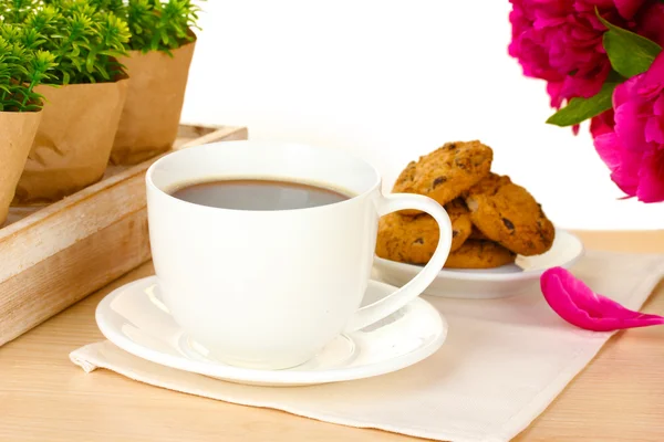 Xícara de café, biscoitos e flores na mesa no café — Fotografia de Stock