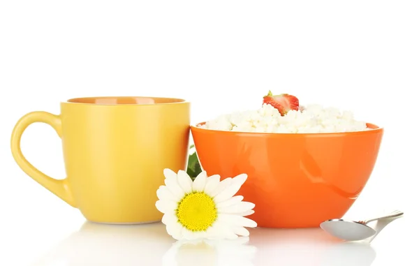 Cottage cheese with strawberry in orange bowl and orange cup with coffee, spoon and flower isolated on white