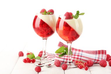 Fruit jelly with berries in glasses on wooden table clipart