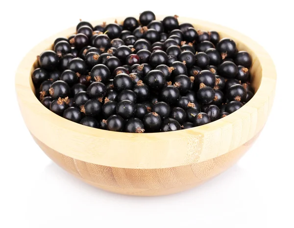 Black currant in wood bowl isolated on white — Stok Foto