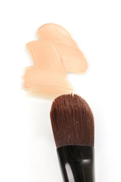 Base cosmética líquida y cepillo aislado en blanco — Foto de Stock
