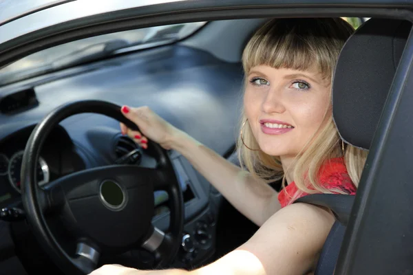 Arabadaki sarışın kadın gülümseyerek mutlu — Stok fotoğraf