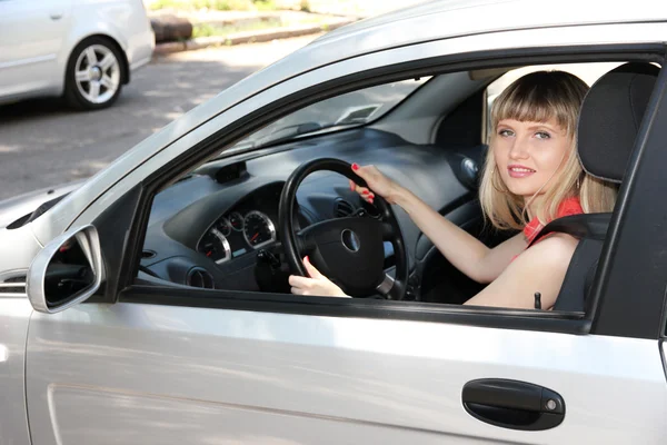 Heureuse femme blonde souriante en voiture — Photo