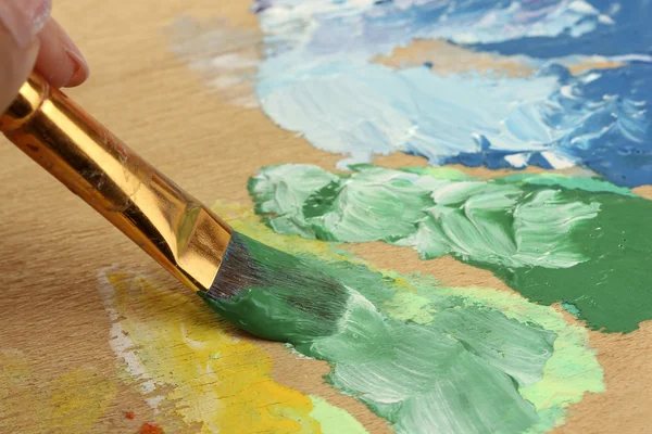 Abstract gouache paint and brush on wooden palette — Stock Photo, Image